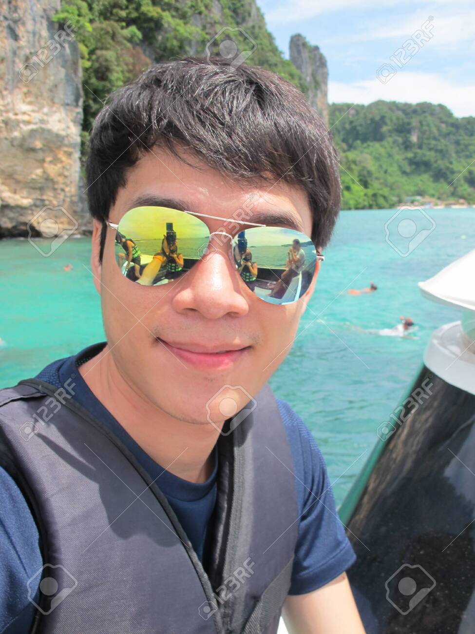 files/119808115-asian-handsome-man-in-swimsuit-with-lifejackets-smiling-and-taking-a-selfie-picture-on-a-boat-in-the.jpg
